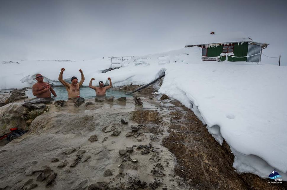 men bathe in hveravellir hot spring on winter