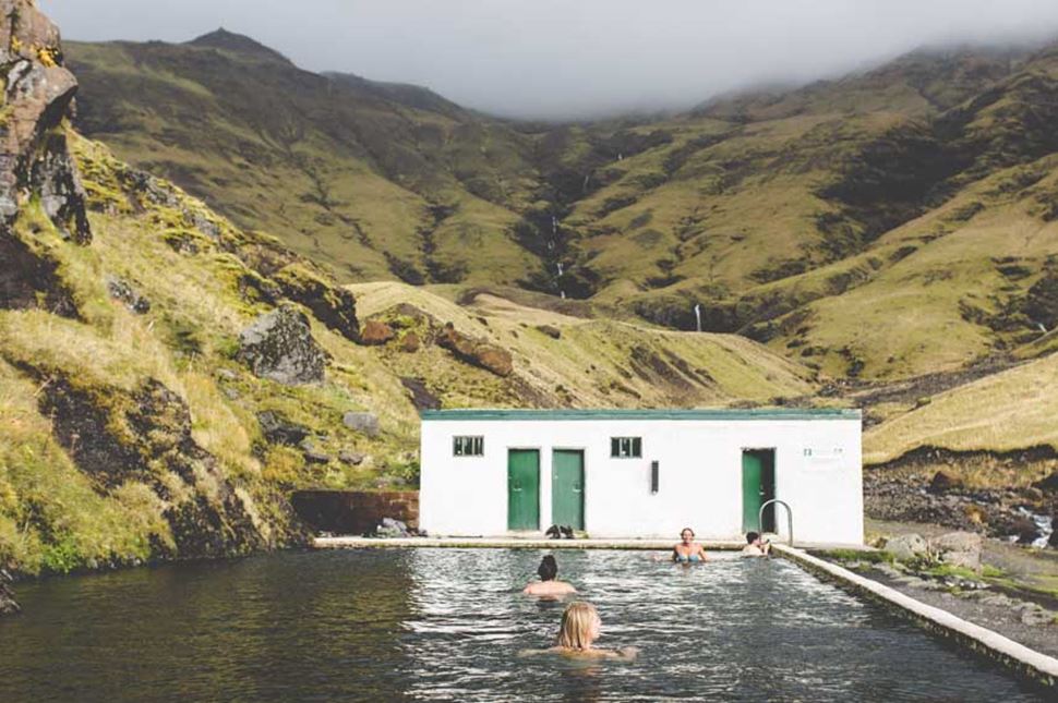 poeple bathe in seljavallalaug hot springs pool