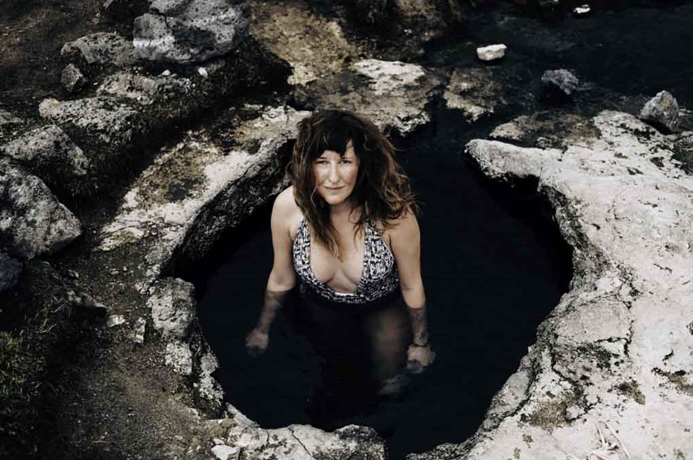 woman standing in landbrotalaug hot sring pool