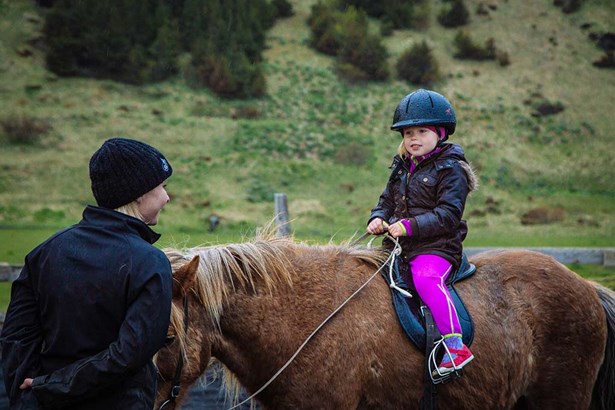 little girl learning hot to ride horse