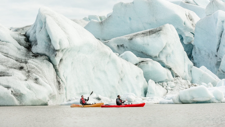 two men paddling near glacier