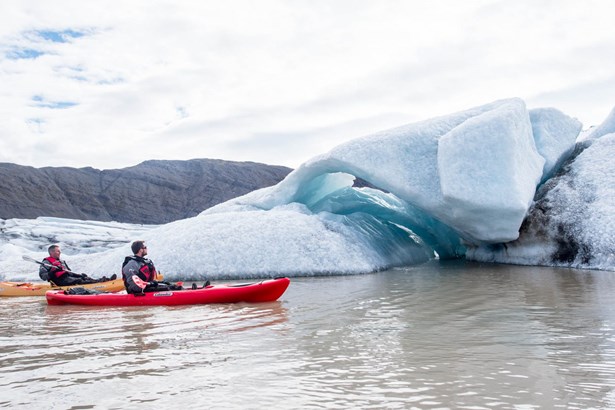 two men kayaking near icebergs of glacier