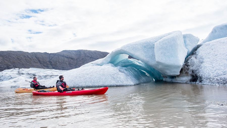 two men kayaking near icebergs