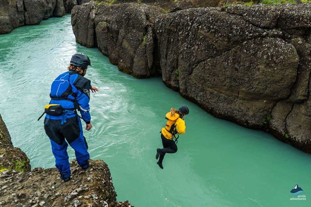 woman jumping into Icelandic river