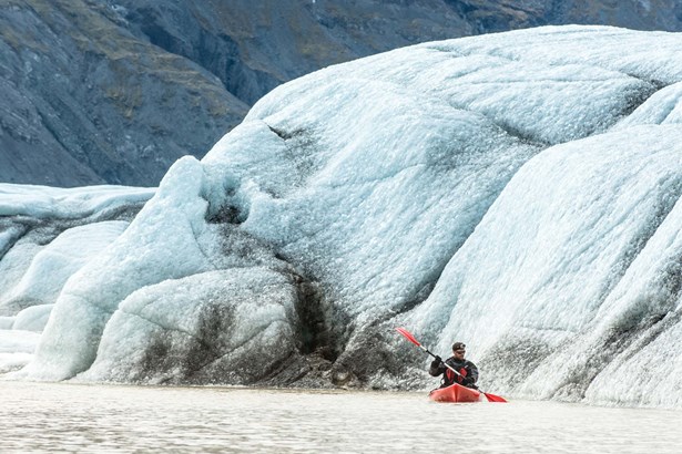 man paddling at Heinaberslon glacial lagoon