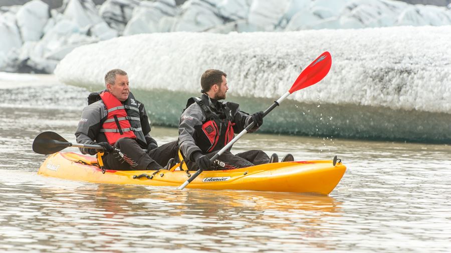 two men paddling in glacial lagoon