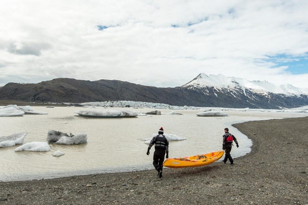 men putting kayak in Icelandic glacier lagoon