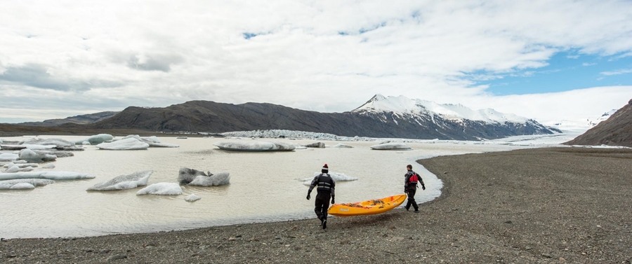 men putting kayak in glacier lagoon