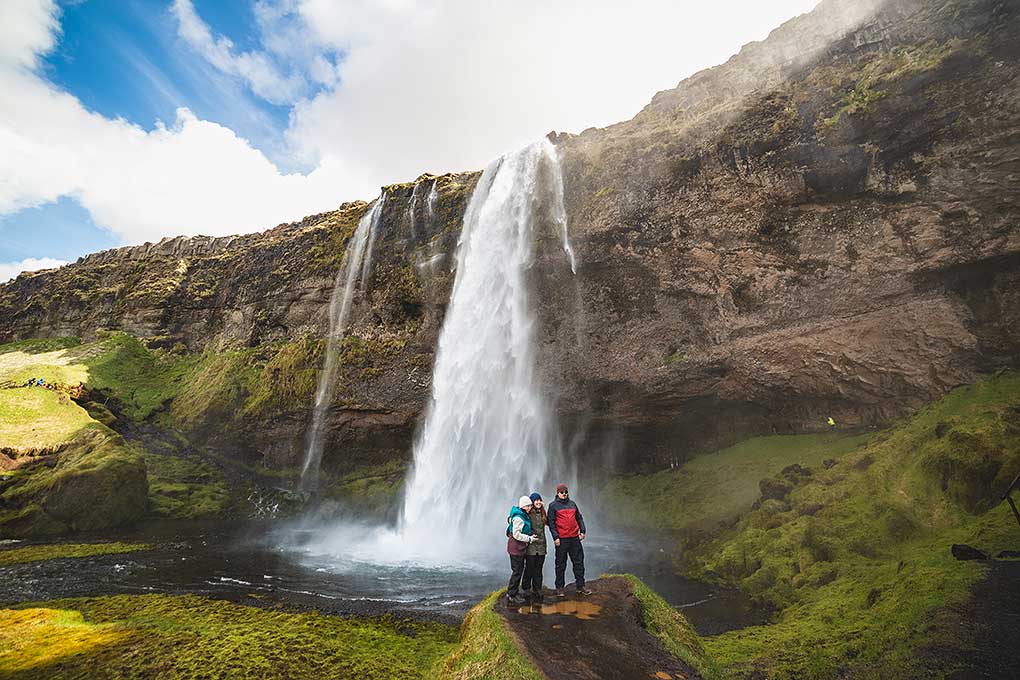 Group of people taking a picture in front of a waterfall in Iceland