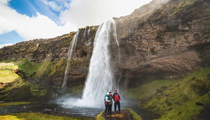 Group of people taking a picture in front of a waterfall in Iceland
