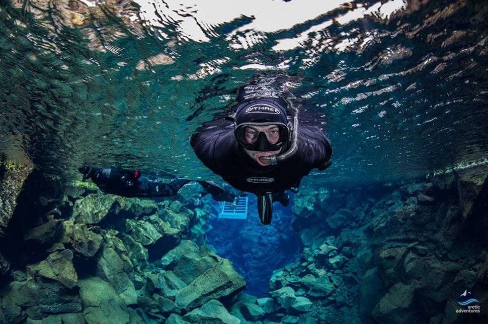 Man snorkeling under the water at Silfra Fissure, Iceland.