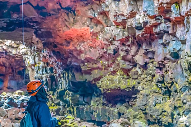 woman exploring rocks of lava cave