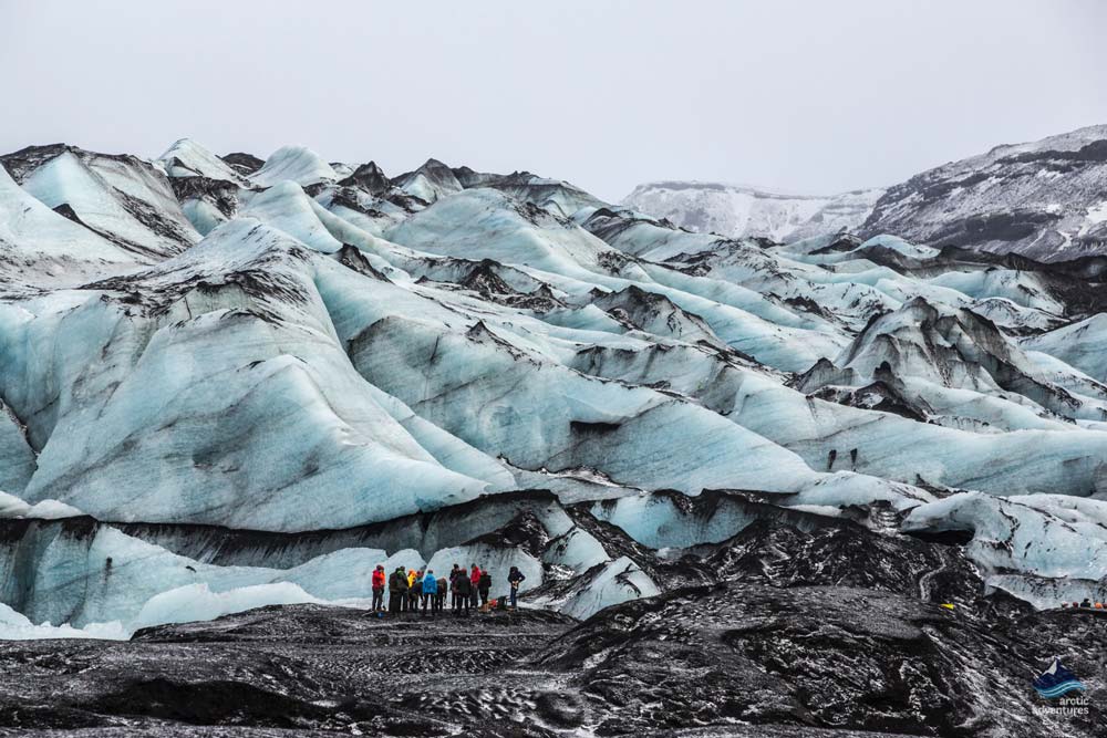 explorers standing by marble glacier ice