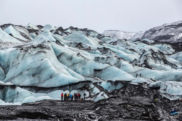 explorers standing by marble glacier ice