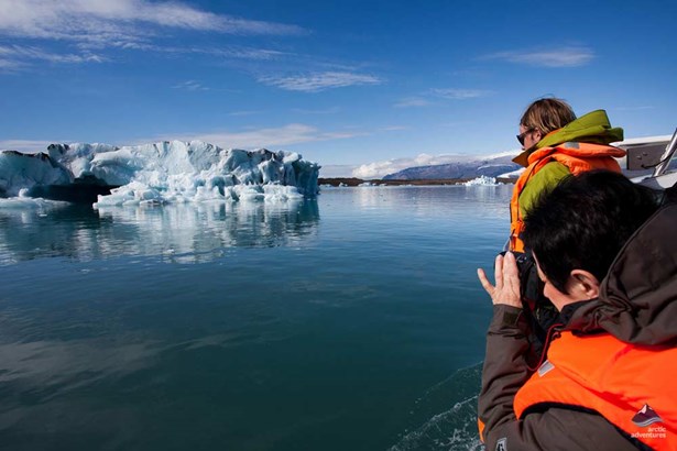 people exploring glacier lagoon by boat