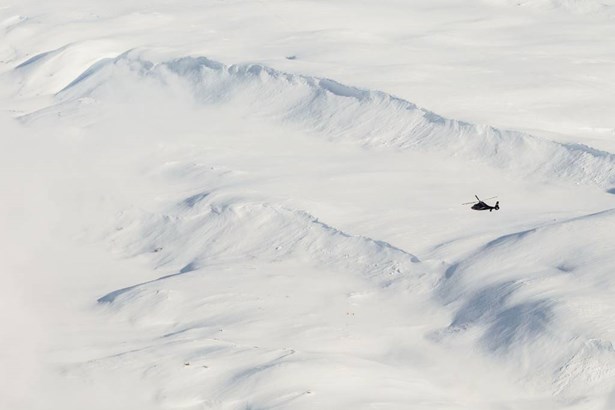 helicopter flying over snowy fields in Iceland