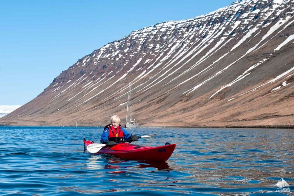 woman paddling near by westfjords mountain