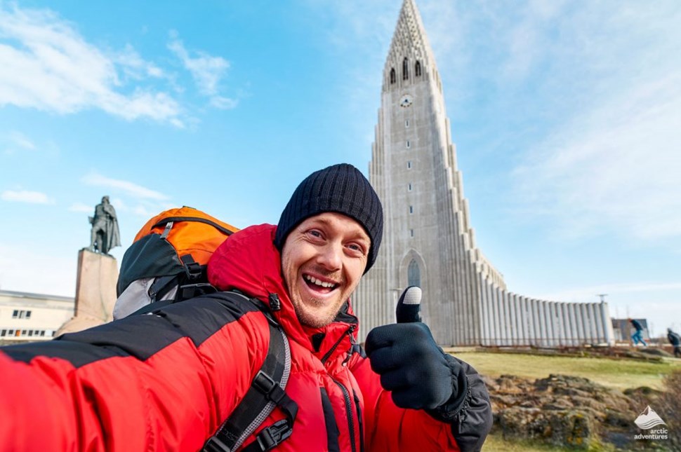 Happy man selfie with an Icelandic church in the background