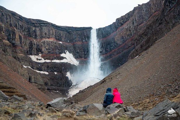 couple enjoys view of Hengifoss Waterfall in Iceland