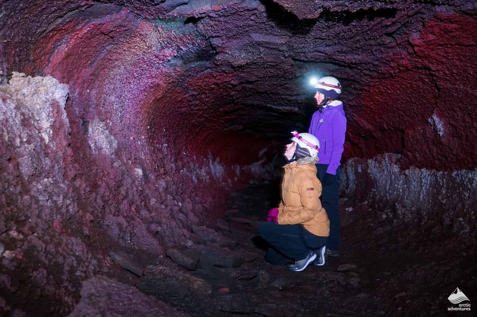 women explore Buri Lava Cave in Iceland