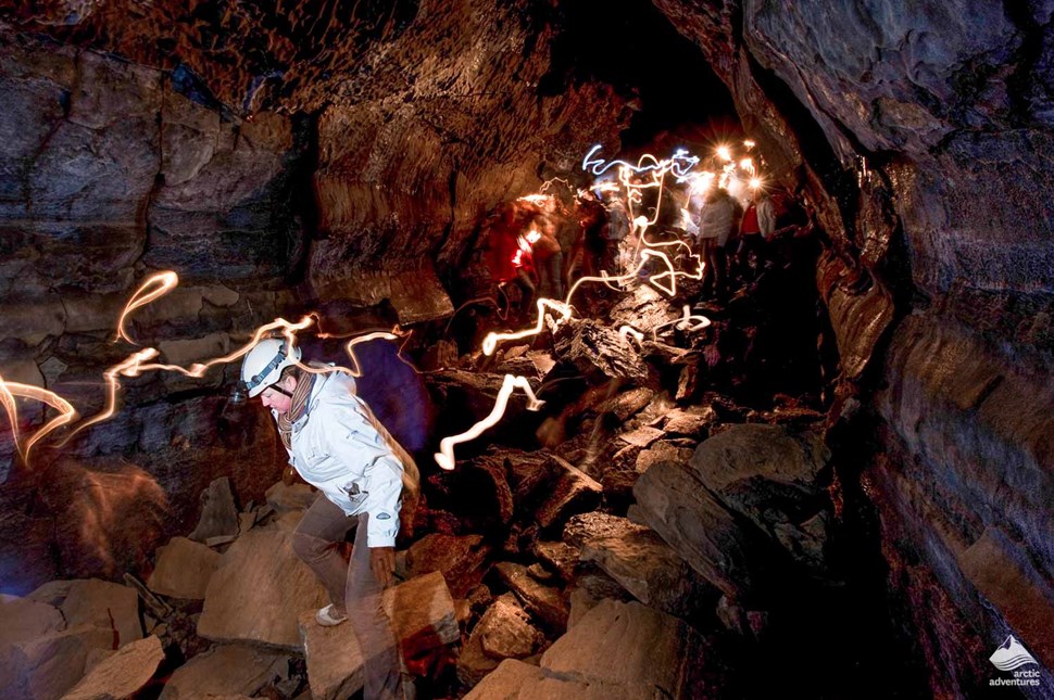 people inside lava cave and light reflections