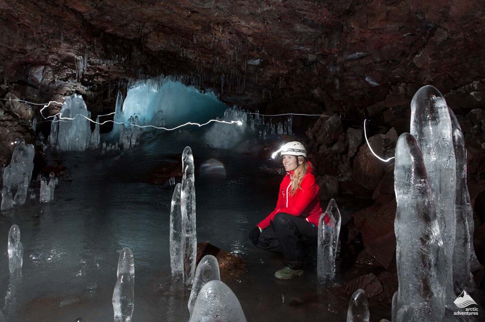 woman inside of lava cave full of stalagmites