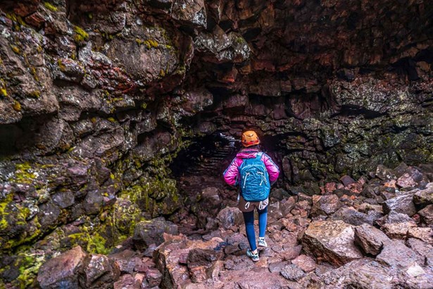 woman going inside of Raufarholshellir lava cave