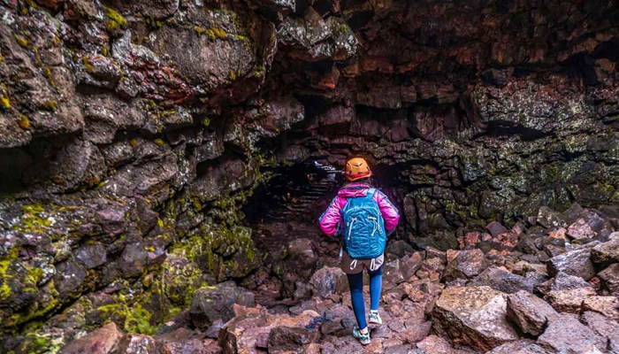 woman going inside of Raufarholshellir lava cave