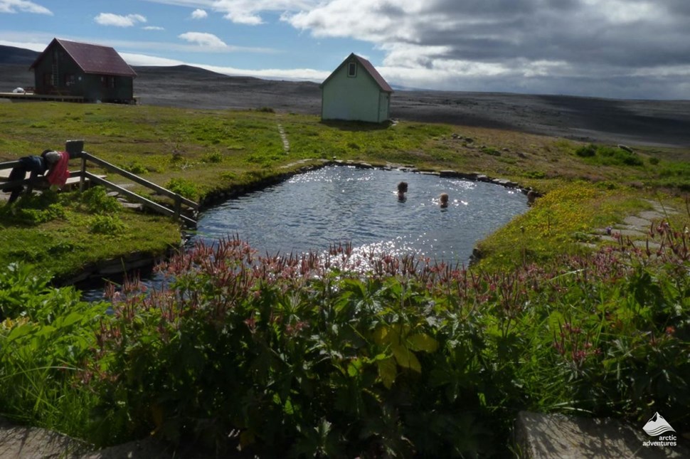 Laugafellslaug pool surrounded by huts near glacier