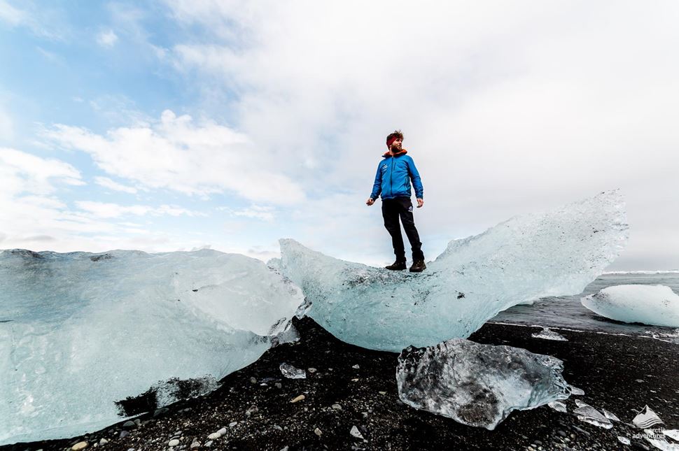 man standing on ice at glacier lagoon