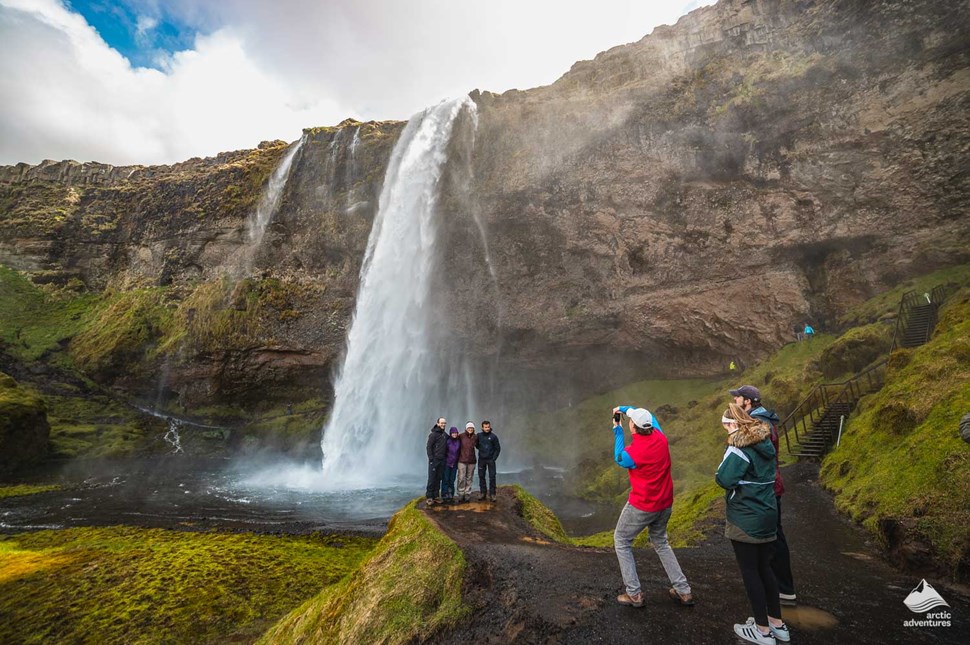 people taking pictures of Seljalandsfoss Waterfall