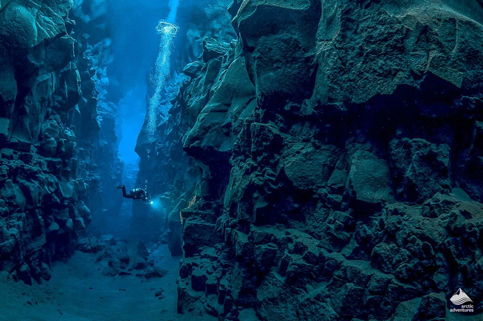 man diving in Silfra between tectonic plates