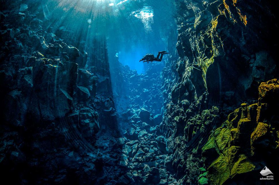 man diving at Silfra Fissure in Iceland