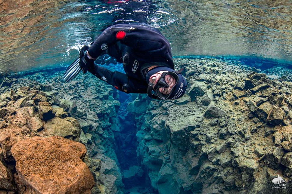 man snorkeling at Silfra Fissure in Iceland