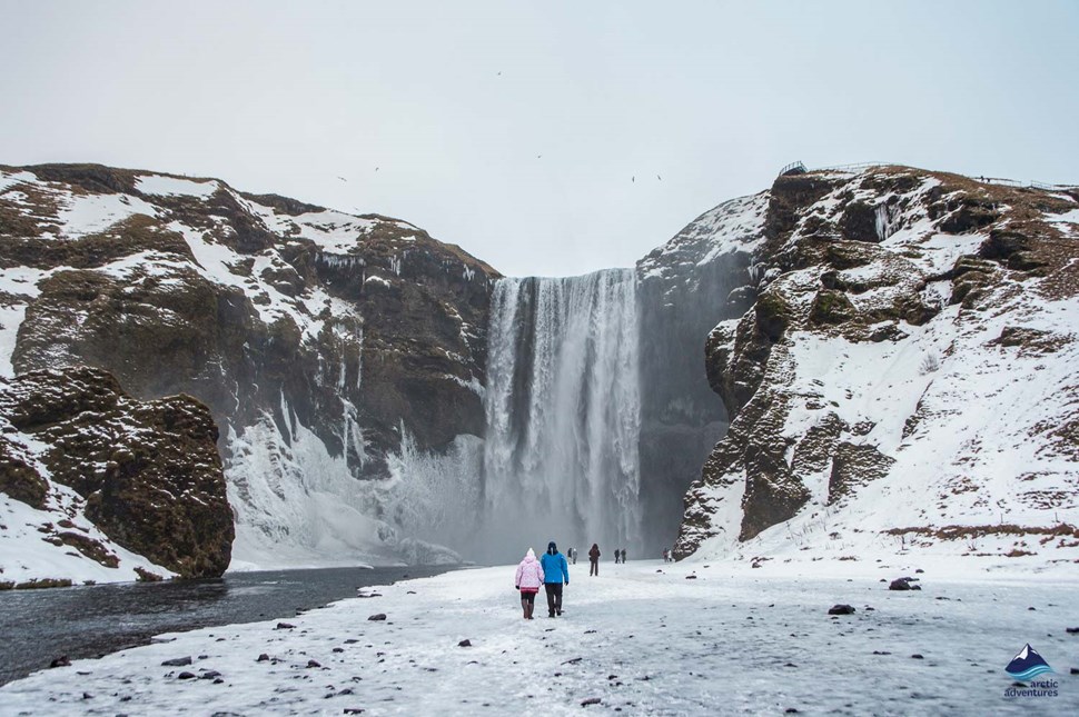 tourists near Skogafoss Waterfall in winter