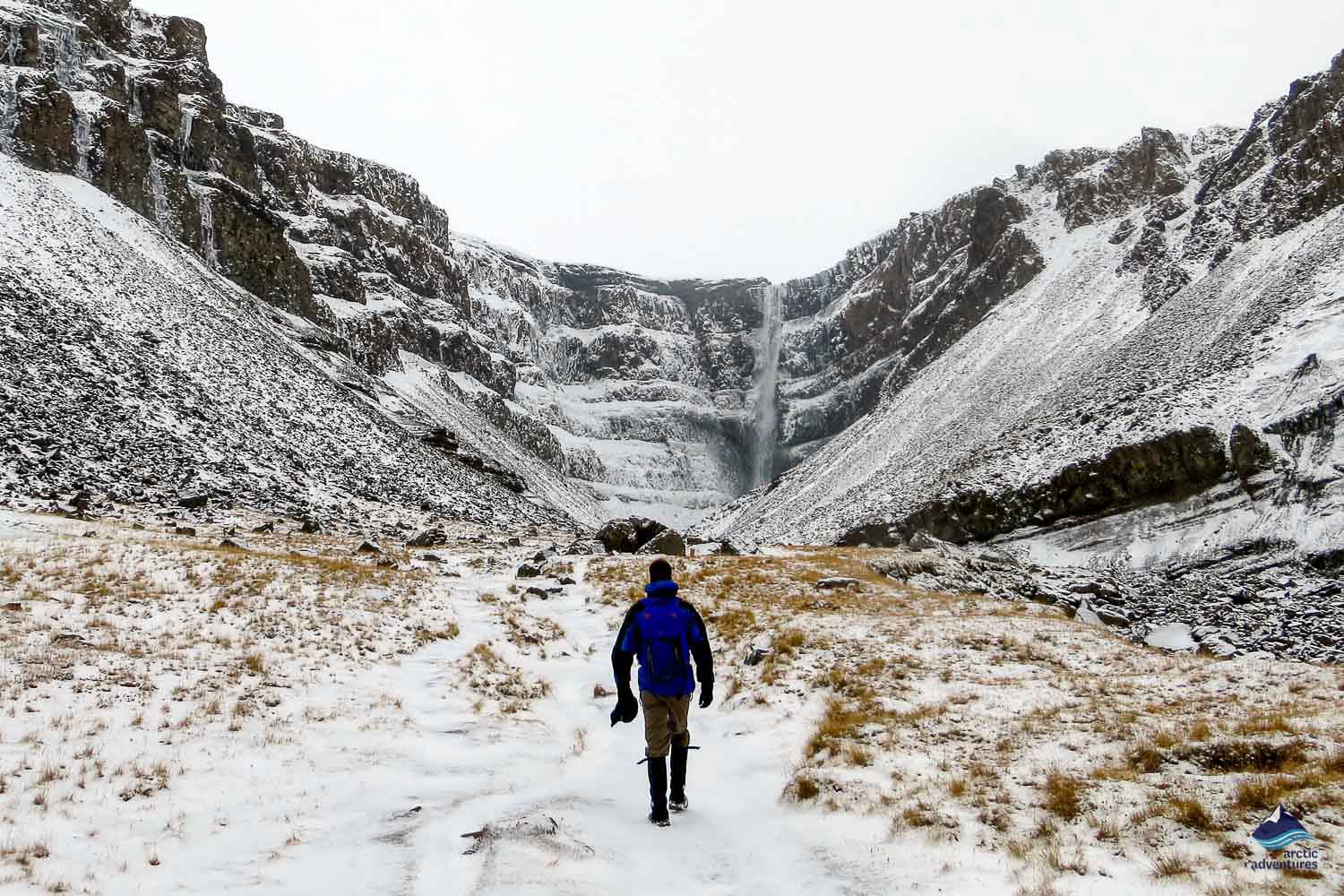 Man near Hengifoss Waterfall in winter