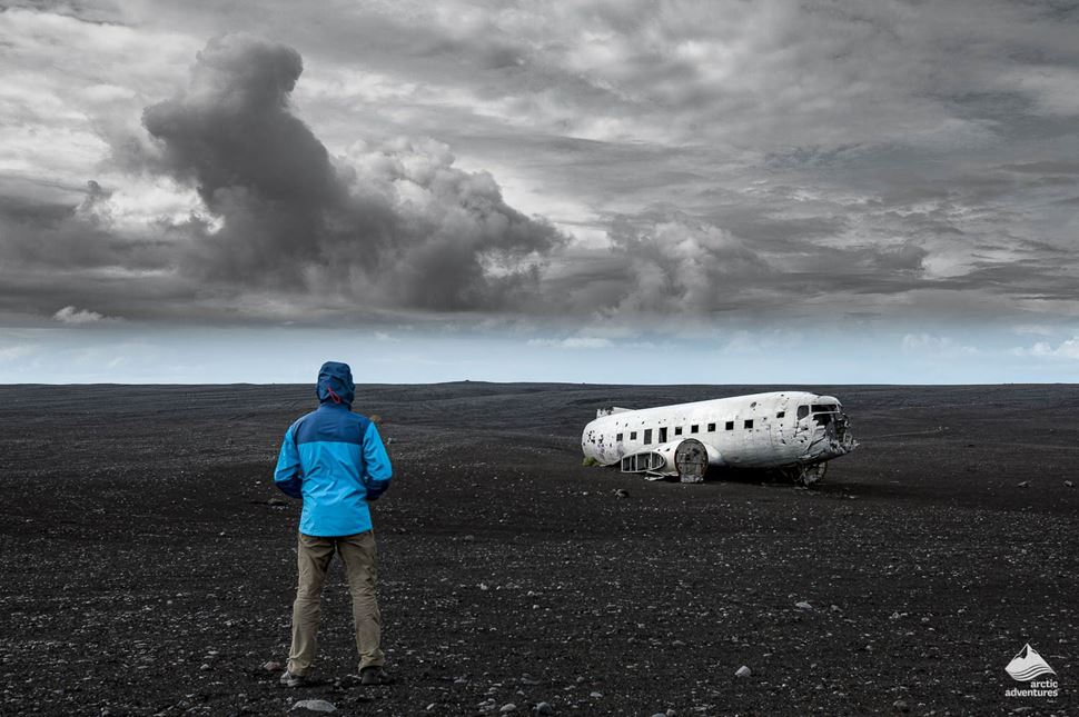 Man standing in front of Solheimasandur Plane Wreck