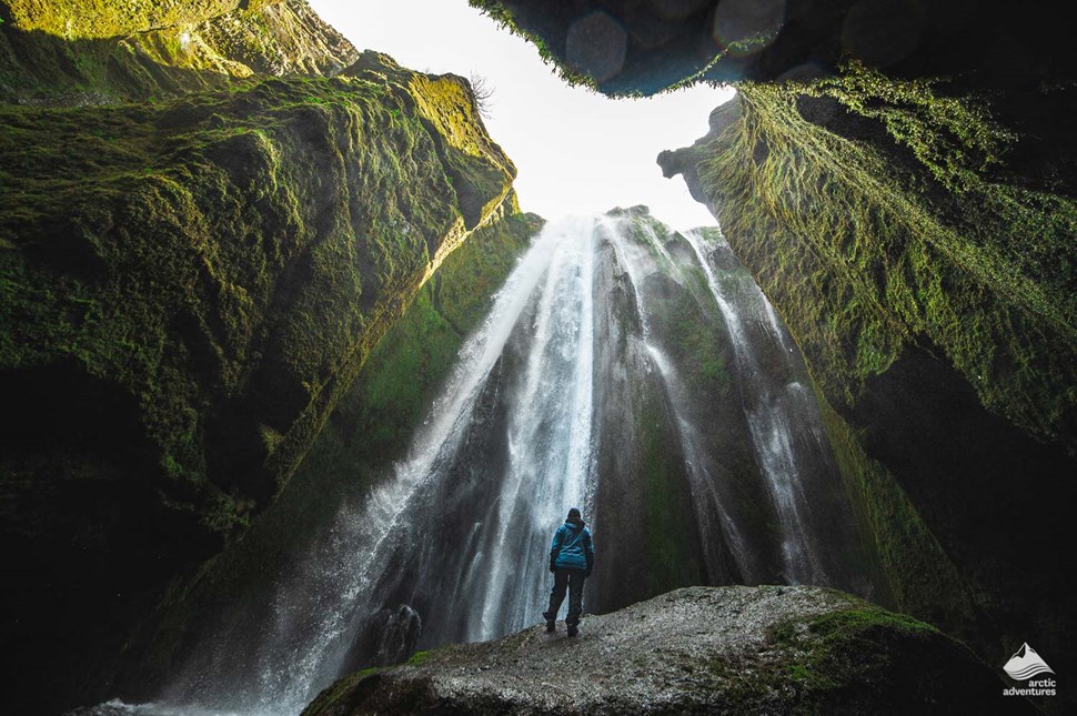 Man standing in front of Gljufrabui Waterfall