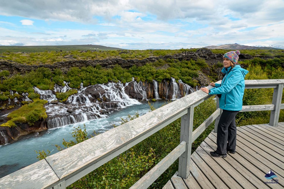 Woman at viewpoint looking to Hraunfossar Waterfall