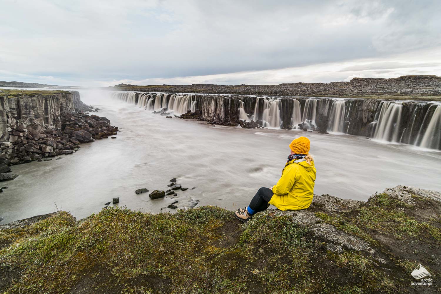 Woman sitting on cliff near Selfoss waterfall