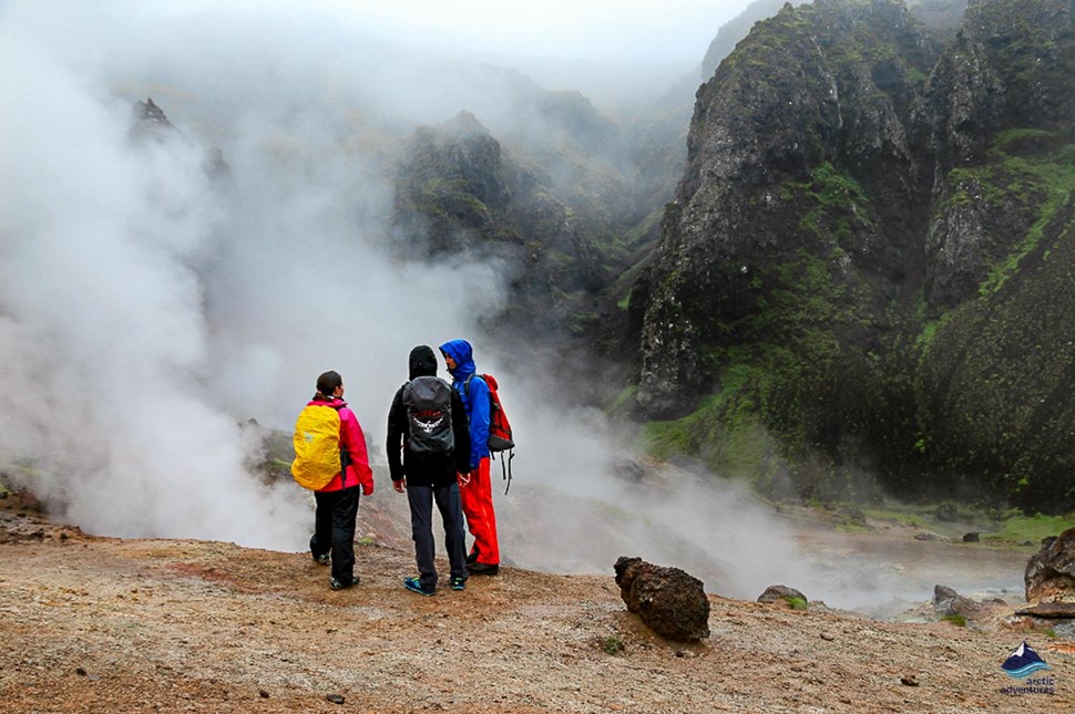 People standing near steaming Reykjadalur hot river