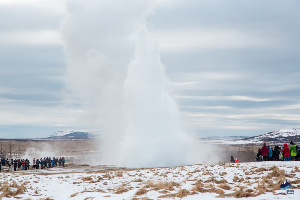 people wathing how geyser erupts in Iceland