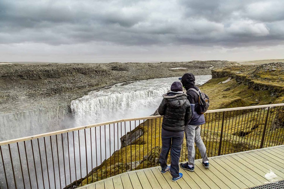 couple looking at Dettifoss waterfall from viewpoint