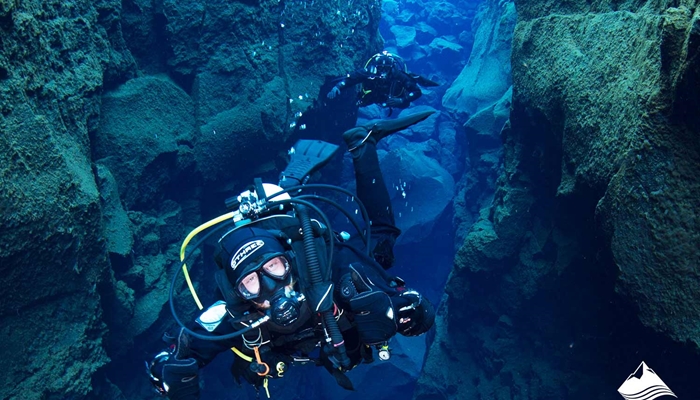 man diving in tectonic ravine of Silfra