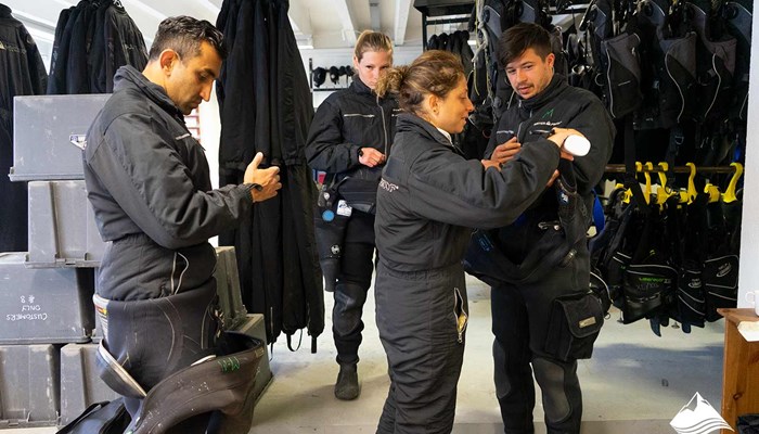 people putting dry suits for diving training