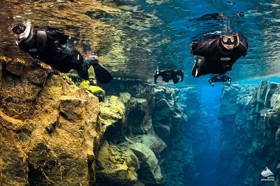 4 divers swimming towards the camera in Silfra Fissure