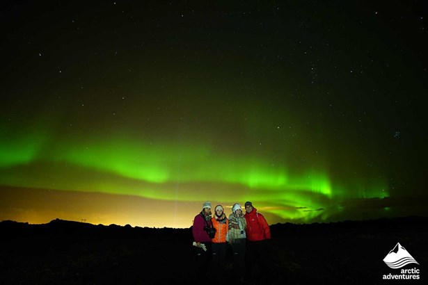 friends taking pictures with Aurora Borealis