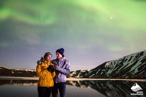 couple watching Northern Aurora in Iceland