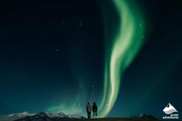 couple watching Aurora Borealis in Iceland