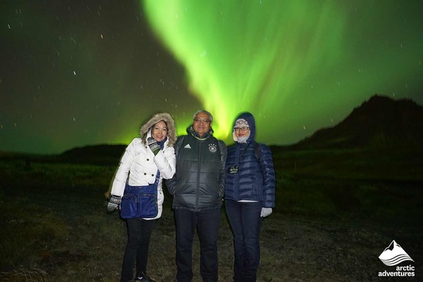 family posing for picture with Northern Lights